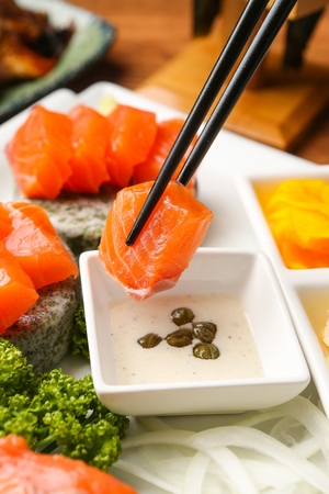 salmon sashimi dipped in sauceの写真素材