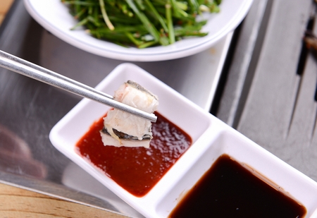 dipping grilled eel in Chojang, spicy sauceの写真素材