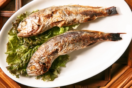 two grilled yellow corvina on plate