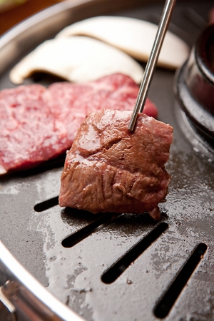 Various beef cuts being grilled on panの写真素材