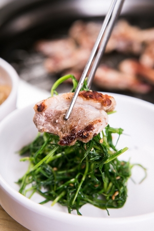 duck meat with greens on chopsticksの写真素材