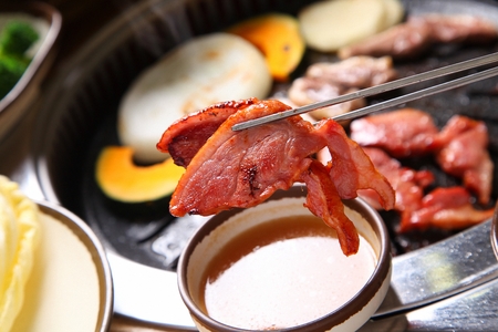 smoked duck dipped in sauce using chopsticksの写真素材