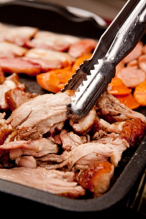 smoked duck being grilled on panの写真素材