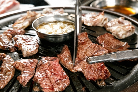 grilled beef on tongsの写真素材