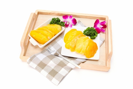 Sliced mangoes on wooden trey, in white backgroundの写真素材