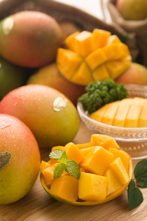 Sliced mangoes on transparent plate, on cutting boardの写真素材