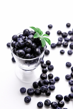 creative shot ofblueberries in cup and on white floorの写真素材