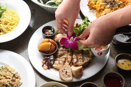 A table full of buffet food such as steak, salads and sushiの写真素材