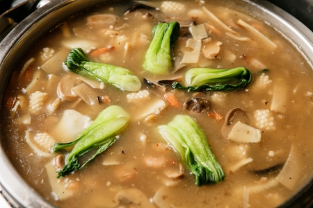 Yusanseul, chinese dish of seafood and pakchoi in pot, buffet background
