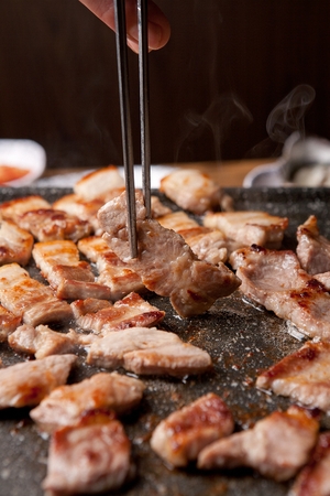 grilled pork belly and pork butt on chopsticksの写真素材