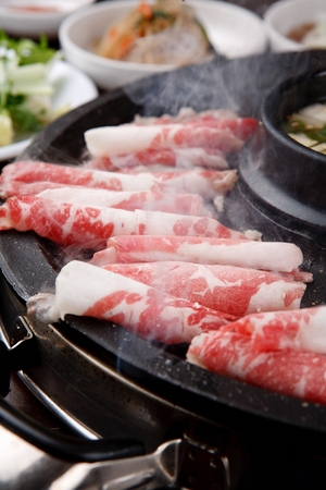thin pork belly grilled on stone grillの写真素材