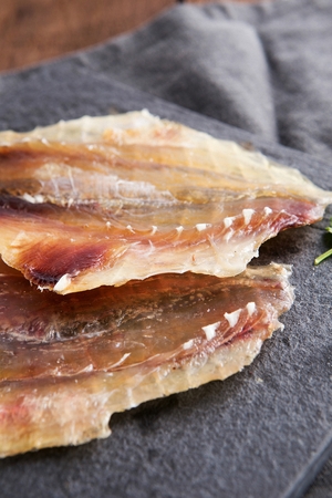 fish jerky on black plateの写真素材