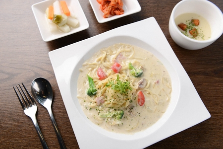 Cream pasta with broccoli and tomatoes, on rectangular plate