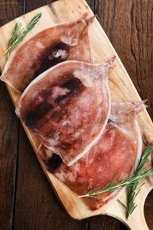 rolled dried squid on wooden cutting boardの写真素材