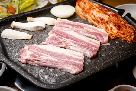 raw pork belly, kimchi, mushrooms and onions on grill