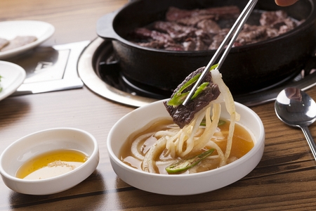 chopsticks grabbing beef and seasoned onionの写真素材