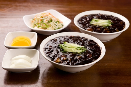 black bean sauce noodles with cucumber on round plate, with sweet radish and onionsの写真素材