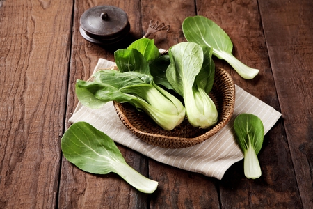 pak choi on table and in basketの写真素材