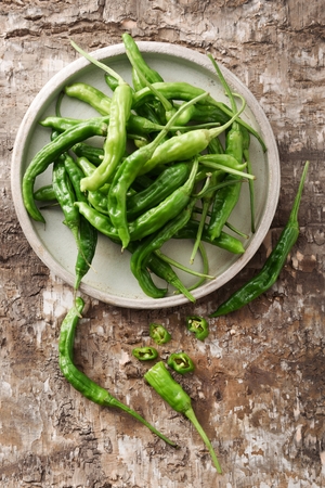 chili on rough surface and on round plateの写真素材