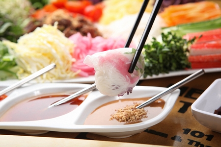 chopsticks grabbing vietnamese spring roll, made of plain noodles and sproutsの写真素材