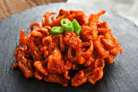 chicken feet with chili on flat black plateの写真素材