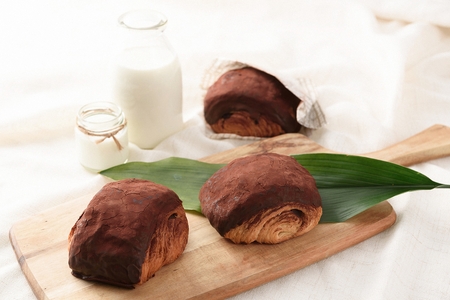 pastry on wooden cutting board, and milk in glass bottleの写真素材