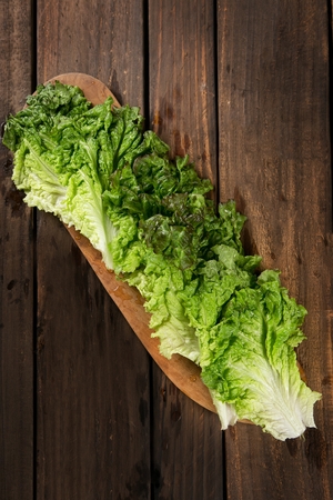 lettuce aligned on wooden plateの写真素材