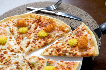 spatula scooping up pizza with sweet potato mousse and fried food