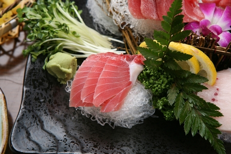 raw tuna with wasabi, lemon and sprouts on plateの写真素材