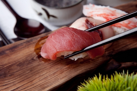 chopsticks grabbing raw tuna sushiの写真素材