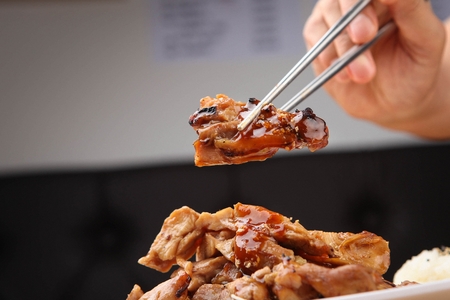 chopsticks grabbing chicken teriyakiの写真素材