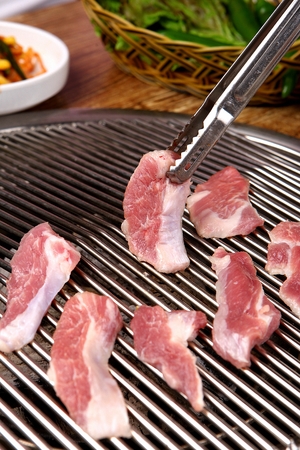 pork being grilled on panの写真素材