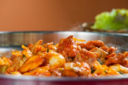 spicy stir-fried chicken with various vegetables and quail eggsの写真素材