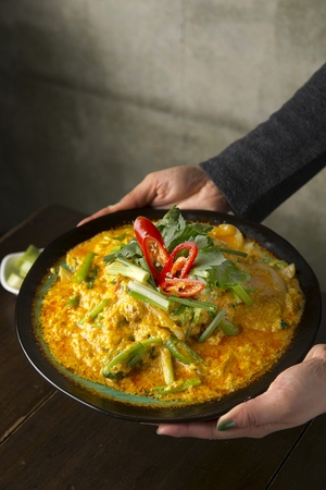 hand grabbing phoo pad pong curry made of crab and coconut milkの写真素材