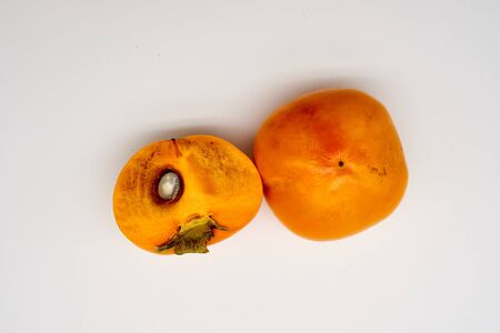 Delicious winter fruits, sweet persimmons on whiteの写真素材