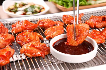 Spicy stir-fried chicken dipped in sauceの写真素材