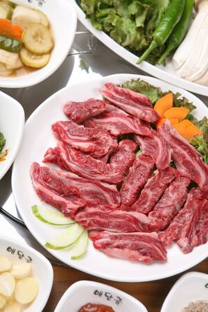 Raw prime rib on plate with side dishesの写真素材