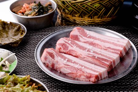 Raw pork belly on iron plateの写真素材