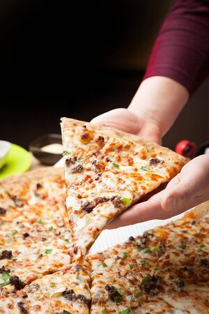 Barbeque beef pizza with one slice held up