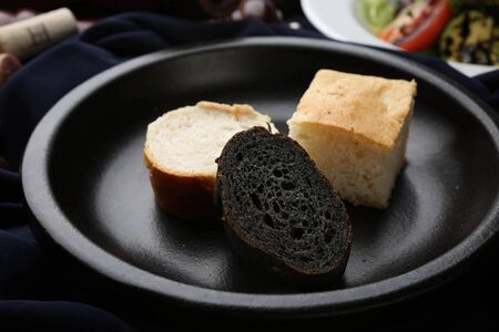 Three breads on black plate