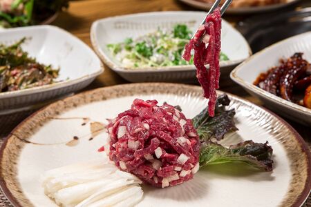 Beef tartare grabbed with chopsticksの写真素材