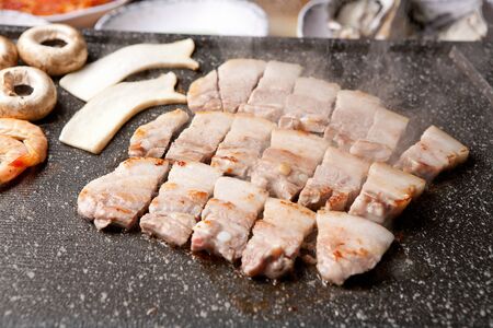 Sliced grilled pork belly with mushrooms on grillの写真素材