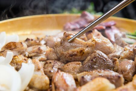 Chopsticks grabbing grilled entrail assortment cooked on grillの写真素材