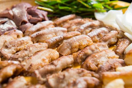 Vegetables and grilled entrails served on grillの写真素材