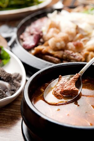 Spoon with Korean beef soybean stew served in Korean bowlの写真素材