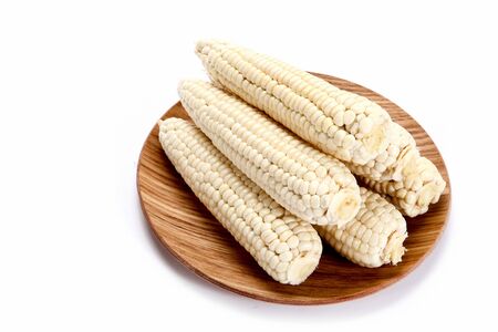 Open, cut corn on wooden plateの写真素材