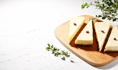 Four Cheese cake slices with dried cranberry on topの写真素材