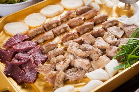 Entrail assortment and vegetable mix being grilled on grillの写真素材