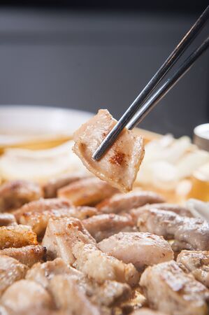 Chopsticks grabbing grilled entrail cooked on grillの写真素材