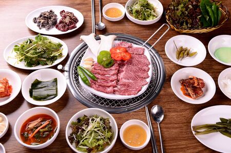 raw sirloin on round plate with vegetables and side dishesの写真素材